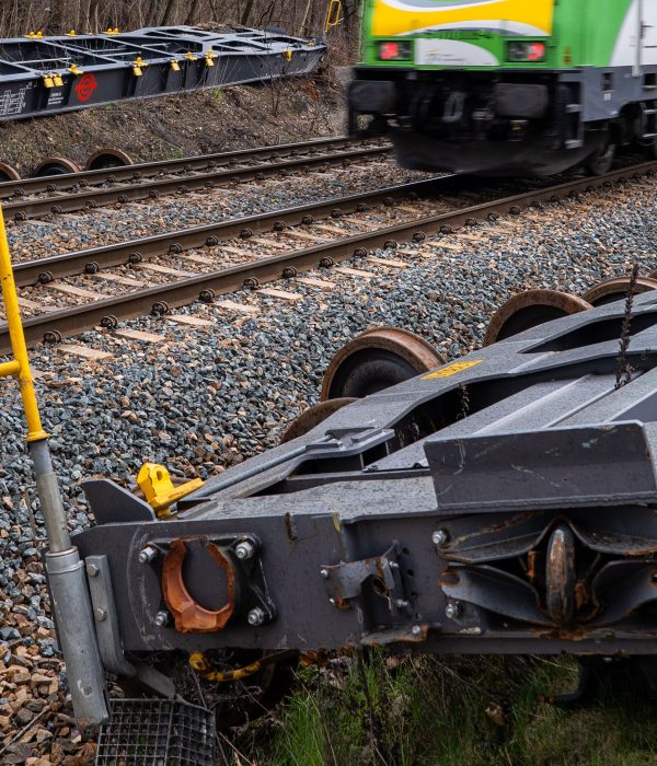 Warsaw, Poland - March 11, 2020: Incoming train and railway track with derailed cargo wagon platforms moved to sides